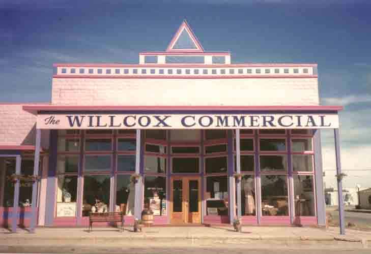 The pink and purple painted façade of an old-fashioned building in Willcox, Arizona. A large sign says "The Willcox Commercial."